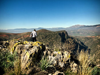 Man standing on landscape against clear sky