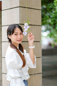 Portrait of young woman holding christmas tree