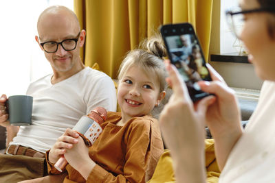 Portrait of smiling young woman using mobile phone at home