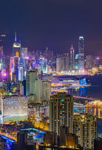 Illuminated buildings in city against sky at night