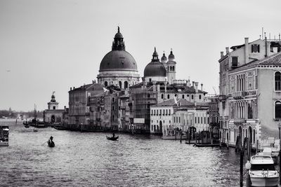 Boats in grand canal with santa maria della salute against sky
