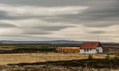 House on field against sky on iceland