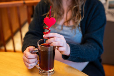 Midsection of woman drinking juice at restaurant