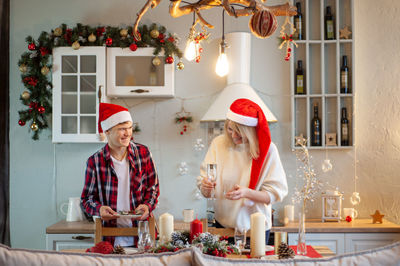 Attractive middle-aged woman and teenage boy prepare the table for christmas dinner. mother and son