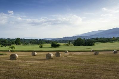 Scenic view of field against cloudy sky