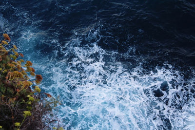 High angle view of waves splashing on rocks