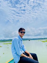 Young man wearing sunglasses against sky