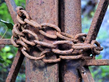 Close-up of rusty chain tied up on metal