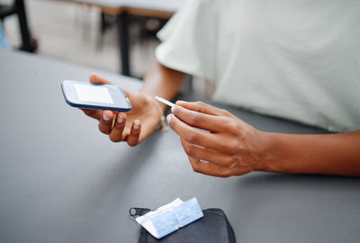 Midsection of man using mobile phone