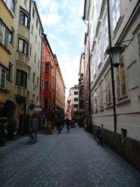 People walking on footpath amidst buildings in city