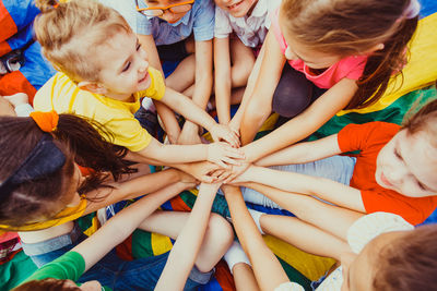 High angle view of children putting hands on top of each other