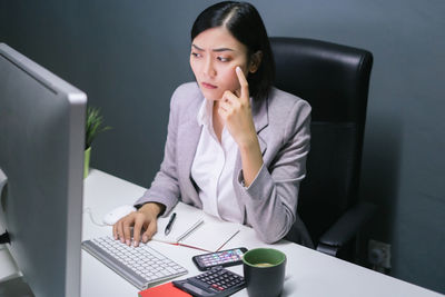 High angle view of businesswoman using computer on desk in office