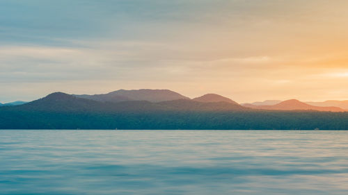 Scenic view of sea and mountains against sky