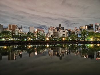 Reflection of illuminated buildings in city at night