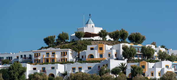 Buildings in town against clear blue sky