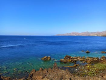 Scenic view of sea against clear blue sky
