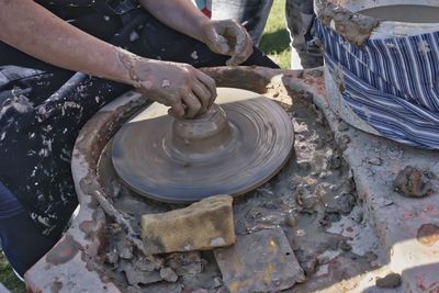 Cropped hands of potter working outdoors