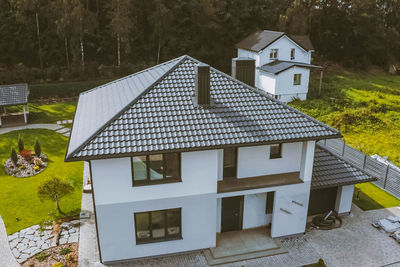 High angle view of cottage amidst trees and buildings