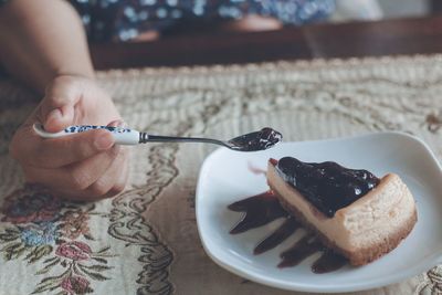 Midsection of man holding cake slice in plate