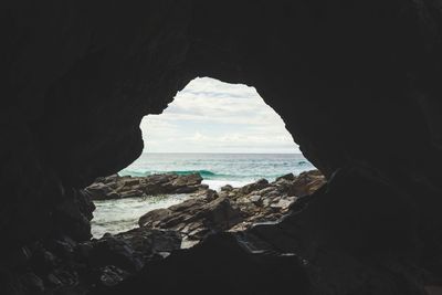 Scenic view of sea seen through cave