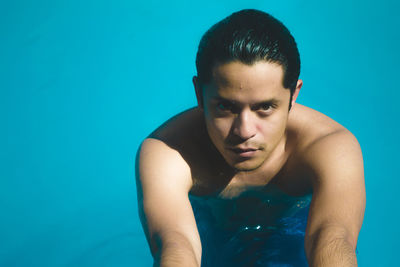 Portrait of young man against blue background