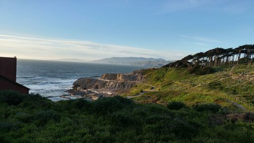 Scenic view of sea and mountains against clear sky