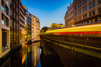 Light trails on bridge over canal in city