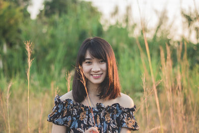 Portrait of young woman standing on field