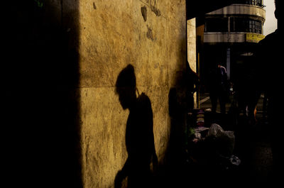 Shadow of man walking on street in city