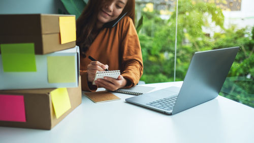 Midsection of woman using laptop on table