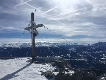 Wind turbines on snowcapped mountain against sky