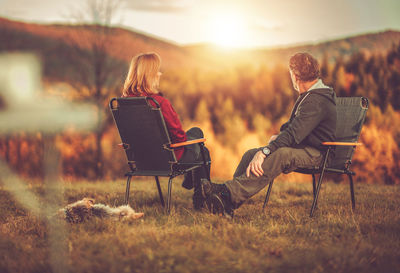 People sitting on chair in field