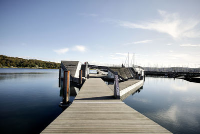 Wooden pier over lake against sky