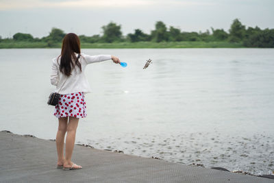 Rear view of woman standing on beach