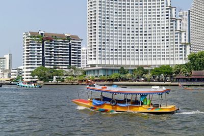 Boats sailing in water by tourists resort