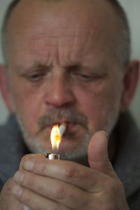 Close-up of mature man igniting cigarette