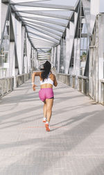 Woman runner running on over a bridge in the city. wellness concept. person