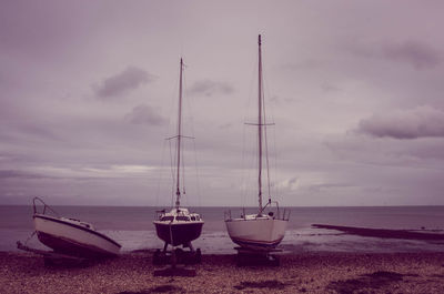 Boats on shore against calm sea