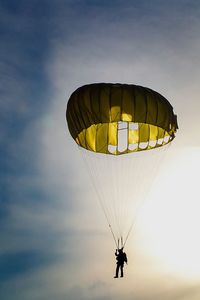 Silhouette of person parachuting against sky