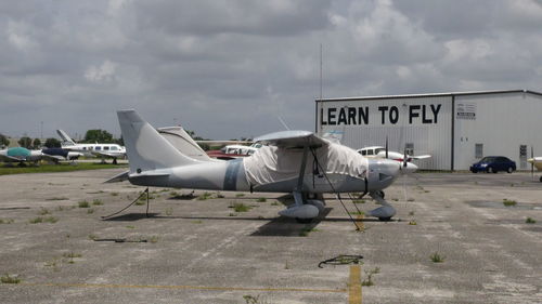 Side view of airplane on airport runway against sky