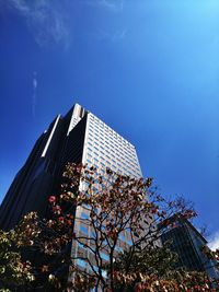 Low angle view of modern building against cloudy sky