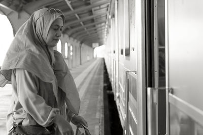 Woman  standing by train at railroad station