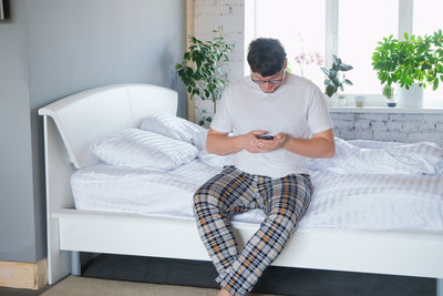 Side view of woman sitting on sofa at home