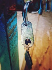 Close-up of rusty chain hanging on metal wall