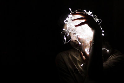 Portrait of man smoking cigarette against black background