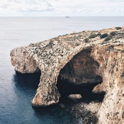 Rock formation in sea against sky