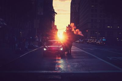 Cars on city street during sunset