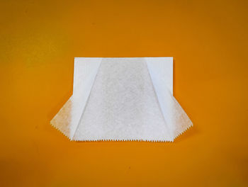 High angle view of white paper against yellow background