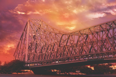 Suspension bridge against cloudy sky