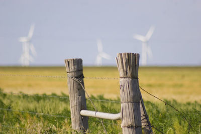 Wooden fence on field against sky